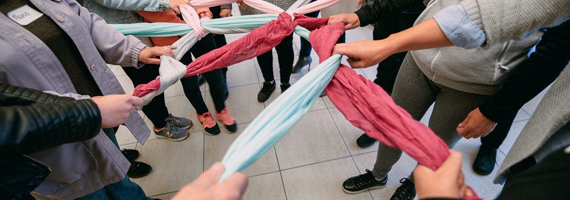 warsztaty - grupa wspólnie trzyma końce tkaniny, tworzące sieć